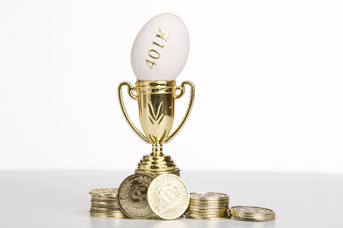 Egg with 401k written on it inside a trophy with gold colored coins